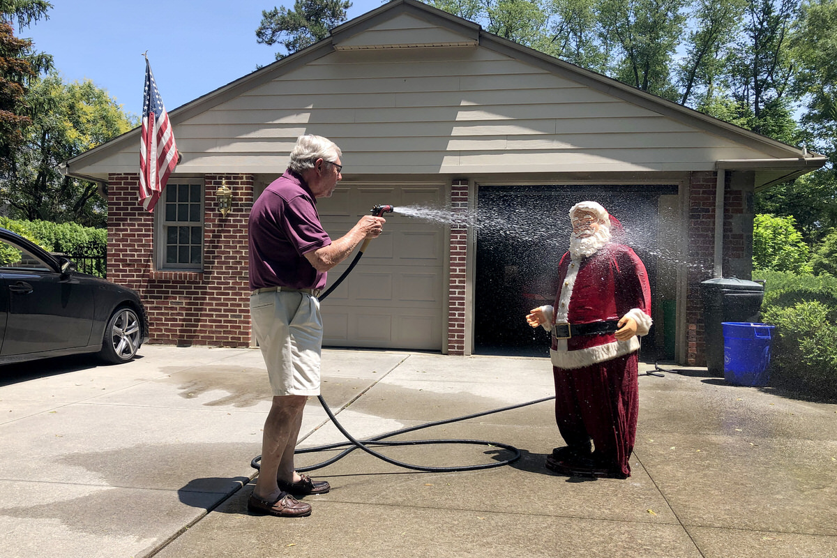 Peter Bull hoses down a fabric-covered Santa he trash-picked in June from the curb of a nearby home in Haddonfield.