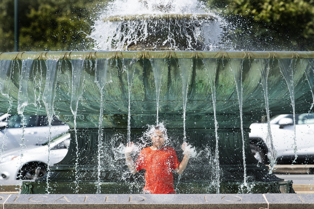 Photo of Alex Paladino cooling off at the Eakins Oval fountain near the Philadelphia Museum of Art.